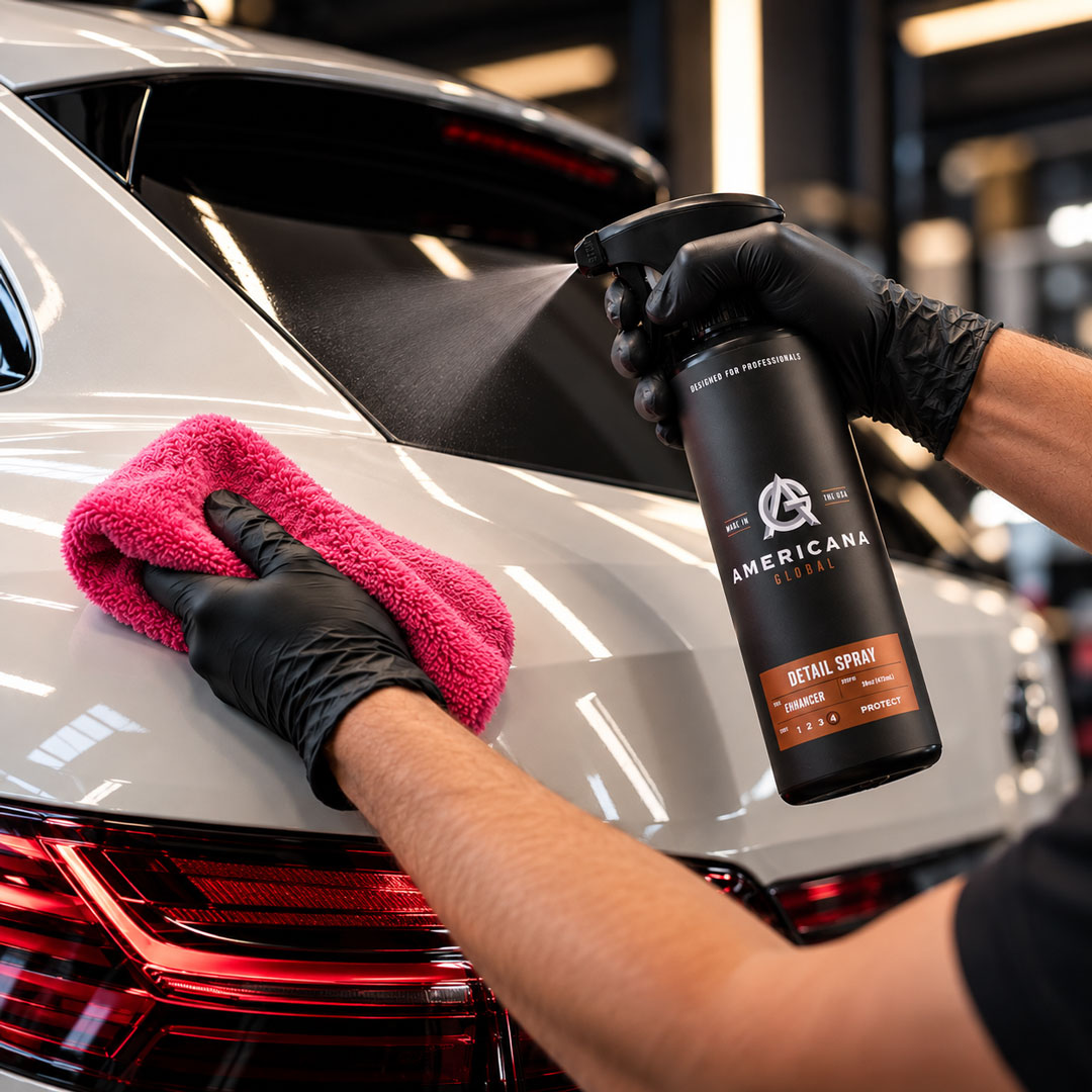 Detailer wiping a vehicle with a microfiber towel while holding Americana Global Detail Spray