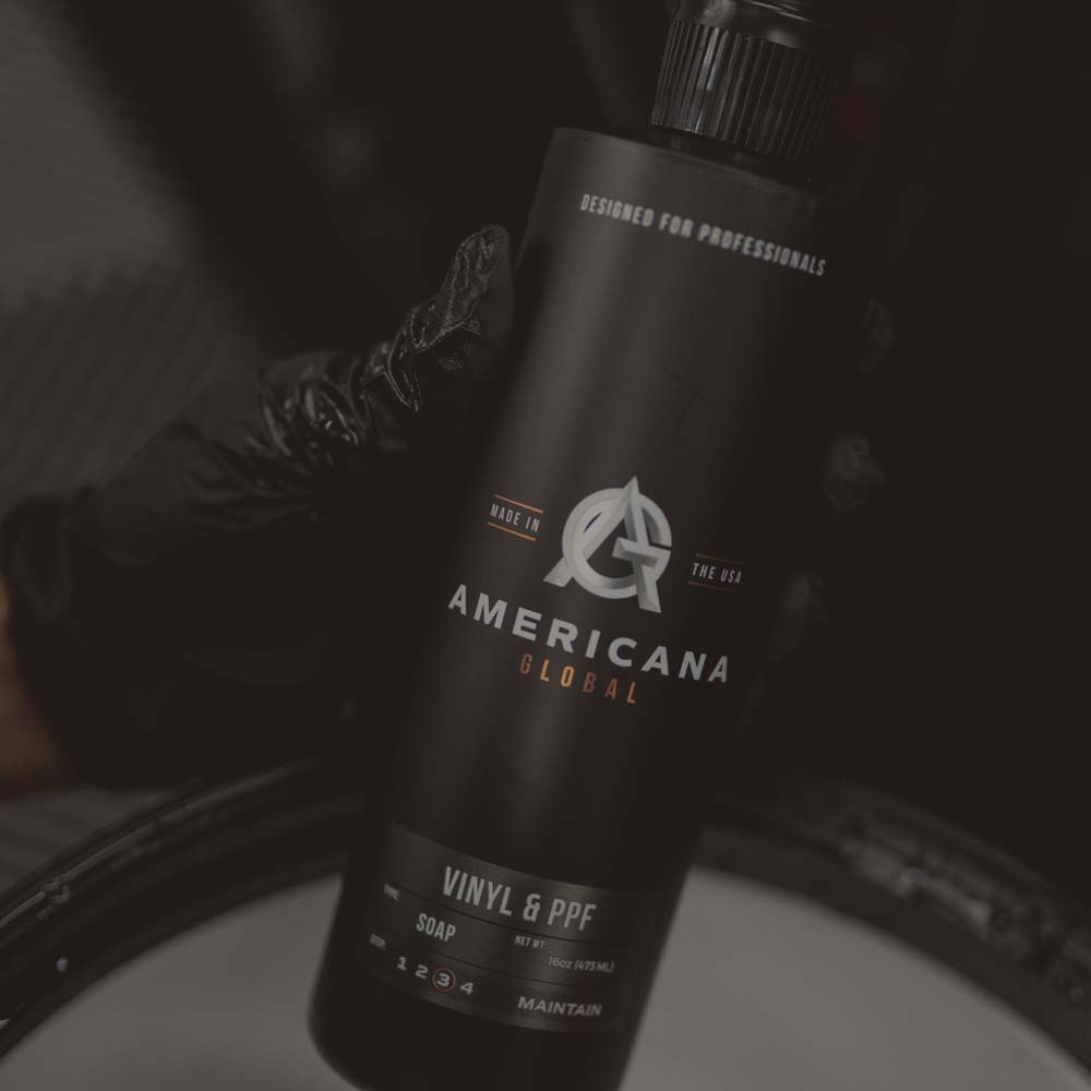 Americana Global Vinyl & PPF Soap bottle held over a vehicle